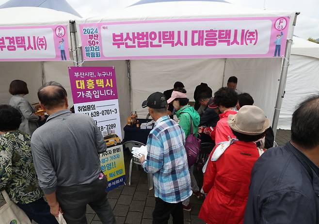Participants visit recruitment booths at a corporate taxi driver job fair, held as part of the “Busan 50+ Job Expo” at Dasom Hall in Busan Citizens Park, Busanjin District, Busan, on Oct. 17, 2024./Kim Dong-hwan
