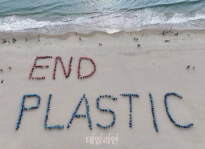 부산 해운대해수욕장에서 16개 환경단체로 구성된 '플뿌리연대'(플라스틱 문제를 뿌리 뽑는 연대) 회원들이 'END PLASTIC' 글귀를 만드는 휴먼사인 퍼포먼스를 하고 있다.ⓒ연합뉴스