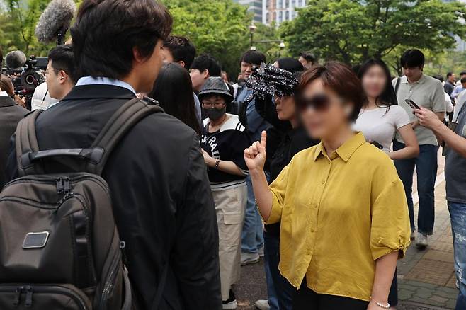 이준석 개혁신당 대선 후보가 28일 서울 여의도 여의도공원에서 유세를 마치고 백브리핑을 하는 도중 한 시민으로부터 이 후보가 전날 토론회에서 여성 신체를 묘사하며 젓가락 발언을 한 것에 대한 항의를 받고 있다. 2025.05.28. 뉴시스