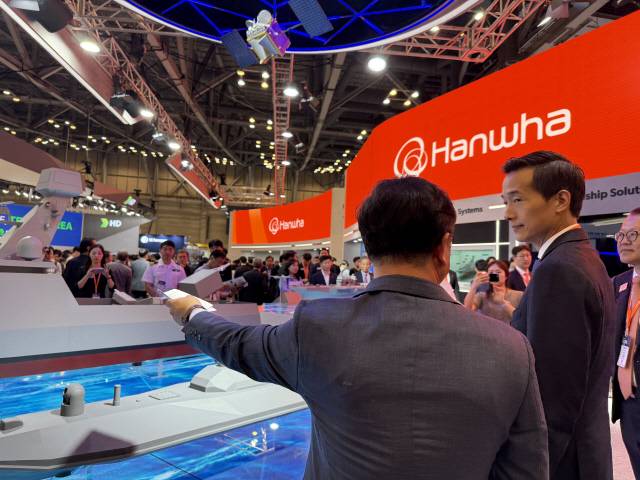 김동관(오른쪽) 한화그룹 부회장이 28일 부산 벡스코에서 열린 'MADEX 2025'에 참석해 한화 부스에서 무인수상정에 대해 설명을 듣고 있다.