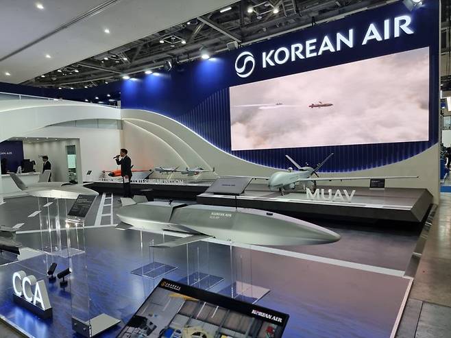 부산 벡스코 제1전시관에서 28일 개막한 '국제해양방위산업전(MADEX 2025)' 대한항공 부스 입구에서 고객들을 맞이하고 있는 인공지능(AI) 소모성 무인 협동 전투기. 사진=김동호 기자
