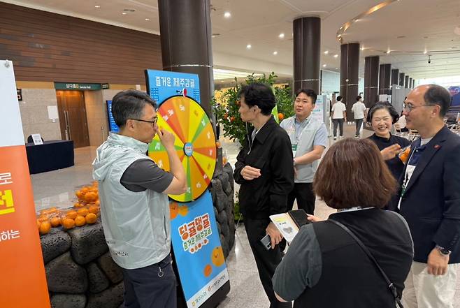 “줄 선다. 돌린다. 웃는다.‘ 감귤 하나로 생긴 풍경. ‘감귤데이’ 10주년 부스 앞. 제주포럼 행사장 한가운데서 감귤을 향한 사람들의 발길이 멈추질 않는다. 룰렛 하나 돌리겠다고 길게 늘어선 줄. 말이 이벤트지, 이건 작은 축제다. (제주농협 제공)