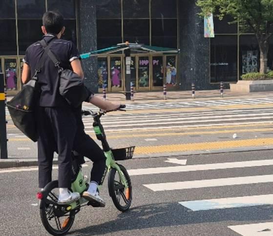28일 오전 8시쯤 부산 서면에서 부산시가 투입한 비상 전세버스를 기다리던 고교생들이 공유형 자전거를 타고 등교하고 있다. 김민주 기자
