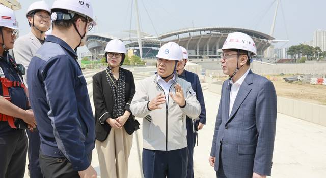 김관영 전북특별자치도지사(가운데))와 우범기 전주시장(오른쪽)이 28일 2036 전주하계올림픽 유치 주요 시설 현장점검에 나서 전주 복합스포츠타운 공사현장에서 관계자들과 얘기를 나누고 있다. 뒤에 보이는 건물은 올림픽 유치시 주경기장으로 활용이 검토 중인 전주월드컵경기장이다. 전북특별자치도 제공