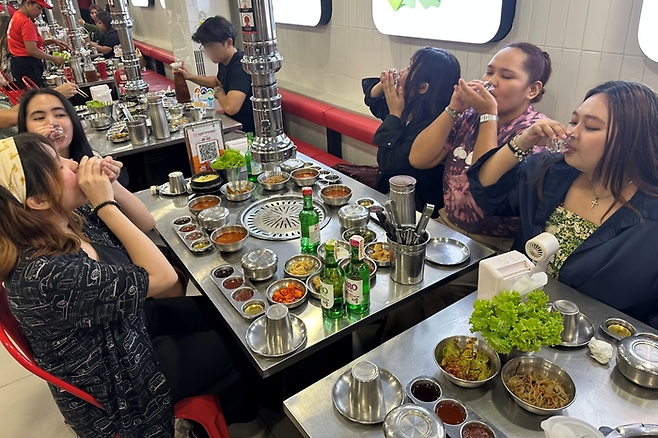 2012년 필리핀에서 설립된 한국식 무한리필 바비큐 전문 프랜차이즈 ‘삼겹살라맛’에서 소비자들이 삼겹살과 ‘진로’ 소주를 즐기고 있다. [사진 출처 = 하이트진로]