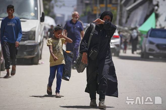 <font style="vertical-align: inherit;"><font style="vertical-align: inherit;">[가자시티=AP/뉴시스] 가자지구 내 팔레스타인 주민들의 절박함이 커지는 가운데 지난 25일(현지 시간) 다섯 자녀를 둔 40세 여성 이슬람 아부 타에마가 가자시티 쓰레기 더미 속에서 빵을 주운 뒤 텐트로 돌아가고 있다. 2025.05.27.</font></font>