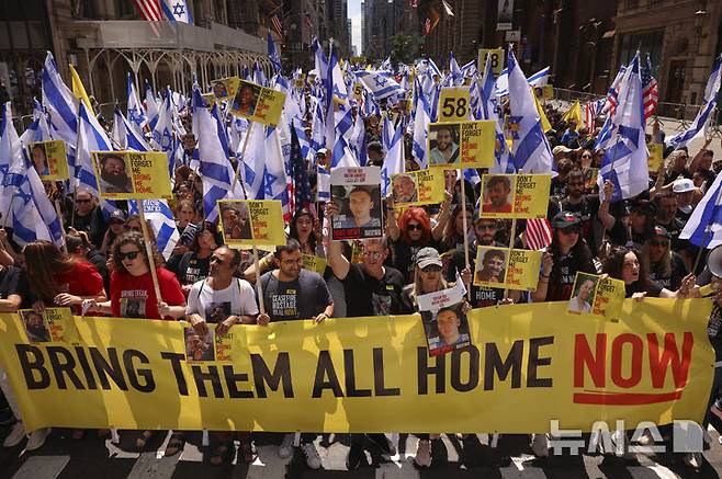 [뉴욕=AP/뉴시스]지난 18일(현지 시간) 미국 뉴욕의 맨해튼 5번가에서 열린 ‘이스라엘의 날'(Israel Day on 5th) 퍼레이드 참가자들이 하마스 억류 인질들의 석방을 촉구하는 현수막을 들고 행진하고 있다. '이스라엘의 날' 퍼레이드는 뉴욕에서 미국 내 유대인 공동체와 이스라엘의 연대를 강조하기 위해 열리는 연례행사이다. 2025.05.28.