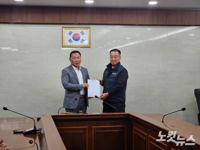 28일 (왼쪽부터) 부산버스조합 성현도 이사장과 부산버스노조 박성훈 위원장이 합의안을 들고 카메라를 향해 미소 짓고 있다. 김혜민 기자