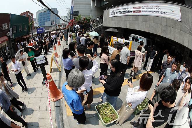 제21대 대통령선거 사전투표 첫 날인 29일 서울 종로구 종로1·2·3·4가동 주민센터 투표소에 마련된 투표소에서 직장인들이 점심시간을 이용해 투표를 위해 길게 줄을 늘어서 있다. 2025.5.29/뉴스1 ⓒ News1 이동해 기자