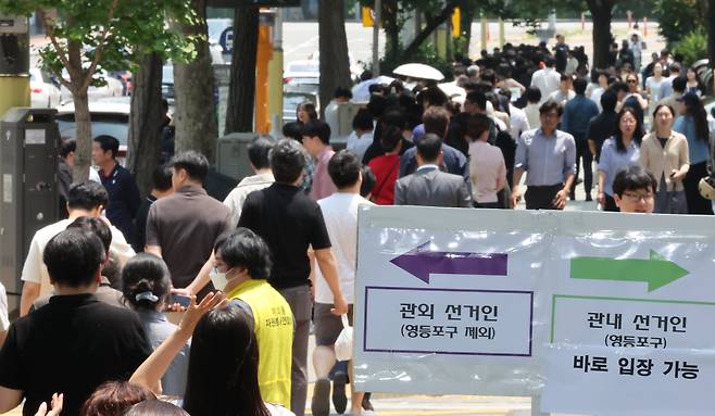 제21대 대통령 선거 사전 투표 첫날인 29일 서울 영등포구 여의동주민센터에 마련된 사전투표소를 찾은 유권자들이 점심시간 중 투표를 하기 위해 긴 줄을 서고 있다. /뉴스1