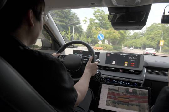 ETRI 자율주행연구차량이 어린이보호구역에서 30㎞ 이하로 속도를 낮추며 운전자 모드로 전환되고 있다.