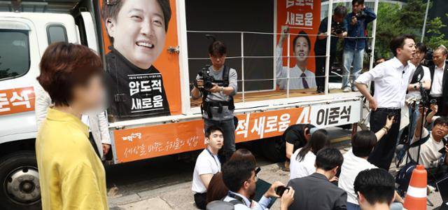 이준석(오른쪽 네 번째) 개혁신당 대선 후보가 28일 서울 영등포구 여의도공원에서 유세를 마치고 취재진 질문에 답변하고 있다. 이 자리에서 한 시민은 전날 생방송 대선 후보 TV 토론 중 이 후보가 여성에 대한 성폭력 행위를 여과 없이 언급한 데 대해 항의했다. 뉴스1