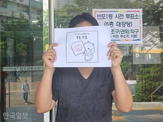 29일 서울 서초구 반포1동주민센터에 마련된 21대 대선 사전투표소에서 주민 허모씨가 '루피' 캐릭터가 그려진 투표 완료 인증용 인쇄물을 들고 서 있다. 전유진 기자