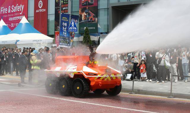 28일 대구 북구 엑스코(EXCO)에서 개막한 2025 국제소방안전박람회를 찾은 관람객이 현대로템이 개발한 '무인소방로봇' 시연을 지켜보고 있다. 대구=뉴스1