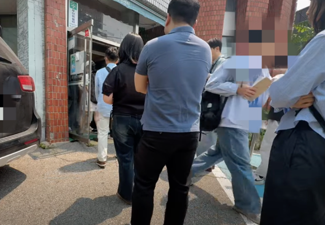 21대 대선 사전투표일 첫날인 29일 서울 서대문구 구 신촌동주민센터 사전투표소 입구에서 한 시민이 투표용지와 회송용 봉투를 들고 건물 입구 밖으로 이어진 줄 맨끝으로 향하고 있다. 유튜브채널 '애국청년 박준영' 캡처