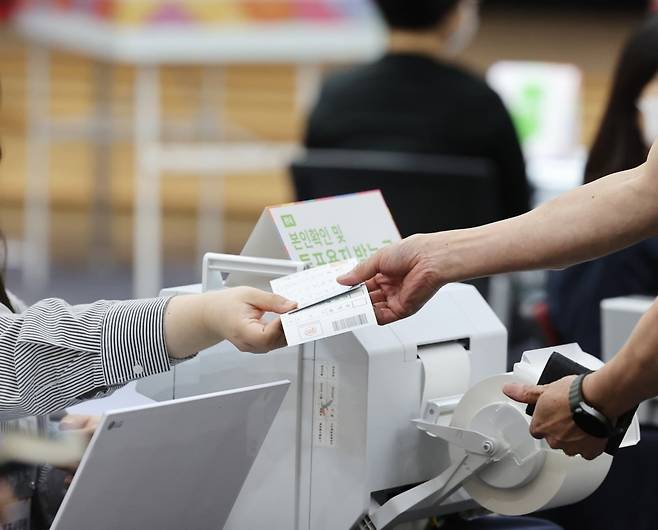제21대 대통령 선거 사전투표 첫날인 29일 울산시 남구청 강당에 마련된 사전투표소에서 유권자가 투표용지를 건네받고 있다. 사진=연합뉴스