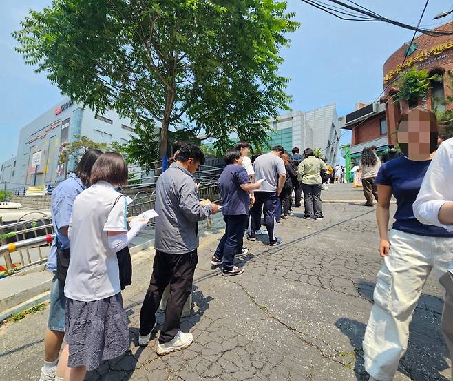 29일 오전 11시 30분쯤 서울 서대문구 구신촌동주민센터 사전투표소에서 유권자들이 배부받은 투표용지와 회송용 봉투를 들고 투표소 밖에 수십 m가량 줄을 서 있다.  지혜진 기자