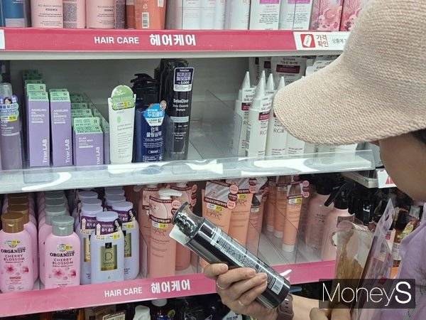 지난 28일 서울 중구의 다이소 매장에서 한 중국인 관광객이 탈모 샴푸를 살펴보고 있다. /사진 = 이수빈 기자