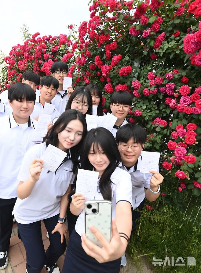 [수원=뉴시스] 김종택기자 = 제21대 대통령선거 사전투표 첫날인 29일 경기 수원시 연무동 행정복지센터에 마련된 사전투표소에서 삼일공업고등학교 3학년 학생 유권자들이 생애 첫 투표를 마친 뒤 장미꽃 앞에서 인증샷을 남기고 있다. 2025.05.29. jtk@newsis.com