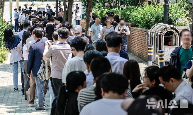 [서울=뉴시스] 정병혁 기자 = 제21대 대통령선거 사전투표 첫 날인 29일 서울 영등포구 여의동주민센터에 설치된 사전투표소를 찾은 유권자들이 투표를 하기 위해 줄 서 있다. 2025.05.29. jhope@newsis.com