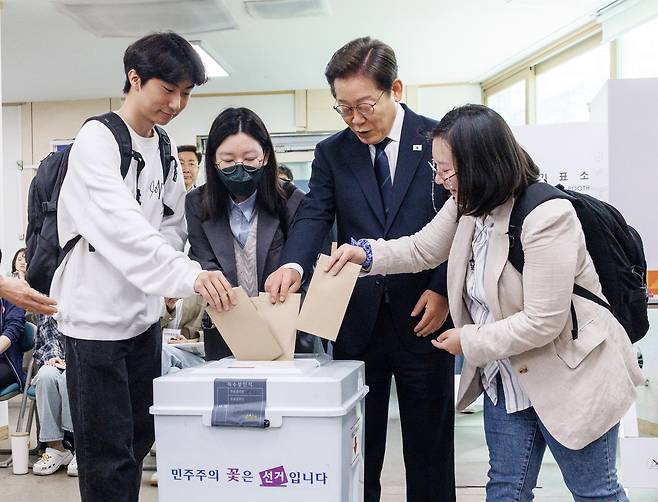 이재명 더불어민주당 대선후보가 제21대 대통령 선거 사전투표 첫날인 29일 서울 서대문구 신촌동 주민센터 투표소에서 청년들과 함께 사전투표를 하고 있다.   공동취재