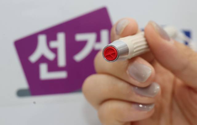 제21대 대통령선거 사전투표를 하루 앞둔 28일 서울 중구 신당동 신당누리센터에 마련된 사전투표소에서 선거관리위원회 관계자가 기표 도장을 점검하고 있다 . 권욱 기자