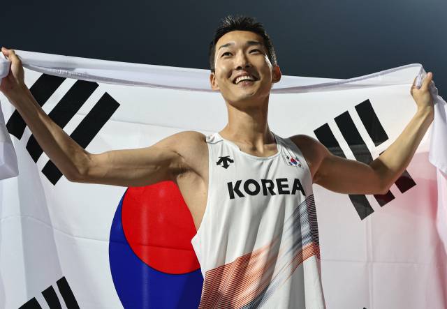 29일 아시아육상선수권 금메달을 딴 뒤 태극기를 펼쳐 보이는 우상혁. 뉴스1