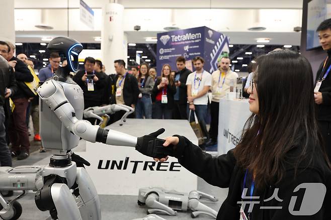 세계 최대 정보기술(IT)·가전 전시회 'CES 2025' 개막일인 7일(현지시간) 미국 네바다주 라스베이거스 컨벤션센터(LVCC)에 마련된 중국 유니트리 부스에서 휴머노이드 로봇 G1이 관람객과 악수하고 있다. 2025.1.8/뉴스1 ⓒ News1 신웅수 기자