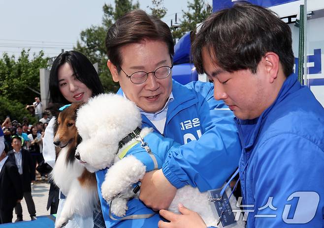 이재명 더불어민주당 대통령 후보가 30일 오후 강원 춘천시 근화동 춘천역 광장에서 열린 집중유세에서 반려견 토리, 뭉치를 안아보고 있다. (공동취재) 2025.5.30/뉴스1 ⓒ News1 이재명 기자