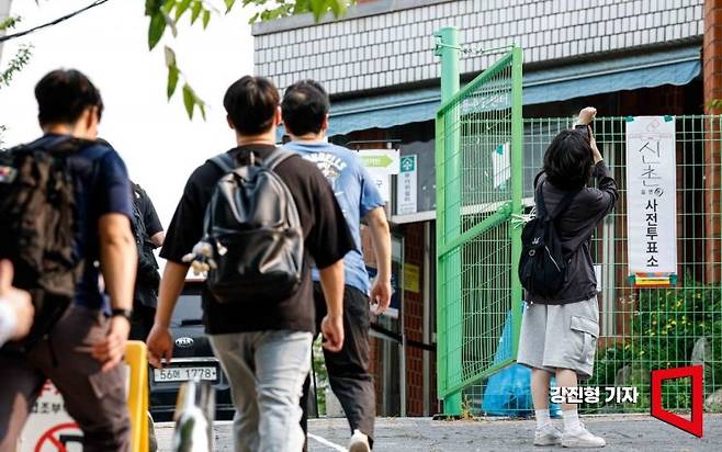 제21대 대통령선거 사전투표 마지막 날인 30일 연세대학교와 이화여자대학교 인근에 설치된 서울 서대문구 신촌동 사전투표소를 찾은 유권자가 투표를 마친 뒤 투표인증을 하고 있다. 2025.5.30. 강진형 기자
