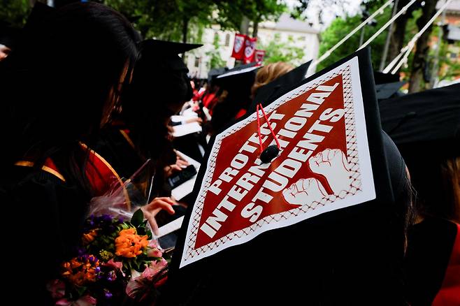 29일(현지 시각) 미국 매사추세츠주 케임브리지 하버드 대학교에서 열린 제374회 졸업식에서 한 졸업생이 유학생들을 지지하는 문구가 새겨진 모자를 쓰고 있다./로이터 연합뉴스