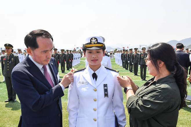 30일 경남 진해 해군사관학교에서 열린 해군·해병대 사관후보생 임관식에서 천안함 46용사 고(故) 김태석 해군원사의 장녀인 김해나(가운데) 소위에게 김소위의 어머니(오른쪽)와 최원일 전 천안함장이 계급장을 달아주고 있다. /해군