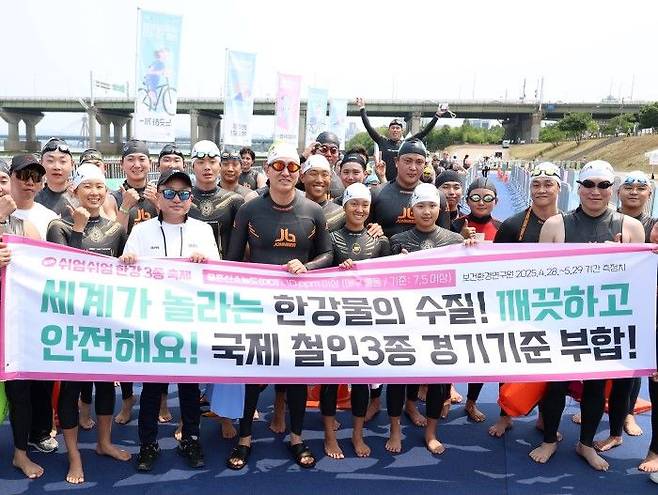 오세훈 서울시장이 30일 '쉬엄쉬엄 한강 3종 축제' 1일차 수영종목 참가 전 시민들과 함께 '깨끗하고 안전한 수질을 자랑하는 한강' 문구가 담긴 현수막을 들고 홍보활동을 펼치고 있다.ⓒ서울시 제공