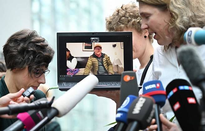 지난 28일 독일 함 고등지방법원에서 패소한 뒤, 사울 루시아노 리우야를 대리한 변호사 로다 베르헤옌(오른쪽)이 노트북을 통해 페루에 있는 루시아노 리우야와 이야기를 나누고 있다. AFP 연합뉴스