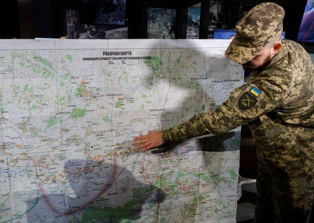 우크라이나 군인이 29일 우크라이나 키이우에서 열린 상설 전시회에서 제2차 세계대전 당시 우크라이나 박물관에 압수된 러시아 군사 지도를 보여주고 있다. 키이우=EPA 연합뉴스