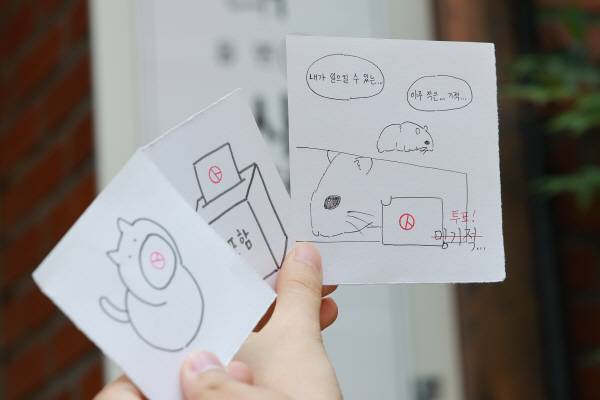 낙성대동사전투표소에서 투표를 마친 유권자들이 투표 인증 용지를 촬영하고 있다. 연합뉴스