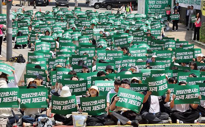 대한간호협회 소속 간호사들이 26일 정부세종청사 보건복지부 앞에서 열린 ‘진료 지원 업무 수행하는 간호사 교육 및 자격 관리 투명화와 법제화 촉구대회’에서 구호를 외치고 있다. [연합뉴스]