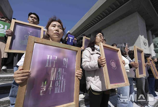 [서울=뉴시스] 김근수 기자 = 기후위기비상행동과 기후정치바람 회원들이 지난달 15일 서울 종로구 세종문화회관 앞에서 열린 기후 단일 의제 대선 TV 토론회 촉구 기자회견에서 캠페인 슬로건이 적힌 실크스크린을 들고 서 있다. 2025.04.15. ks@newsis.com