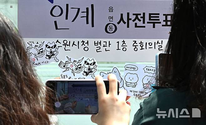 [수원=뉴시스] 김종택 기자 = 제21대 대통령선거 사전투표 둘째날인 30일 경기 수원시청 별관에 마련된 사전투표소에서 투표를 마친 유권자들이 투표 도장이 찍힌 그림을 들고 기념촬영을 하고 있다. 2025.05.30. jtk@newsis.com