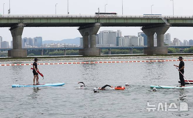 [서울=뉴시스] 조수정 기자 = 오세훈(가운데) 서울시장이 30일 서울 한강에서 제2회 쉬엄쉬엄 한강3종 축제 사전점검 및 깨끗한 한강 수질을 홍보하기 위해 잠실대교 남단 수중보에서 뚝섬수상안전교육장까지 1km 구간을 '수질 환상적'이라고 적은 부표를 몸에 매고 수영으로 도하하고 있다. 2025.05.30. chocrystal@newsis.com