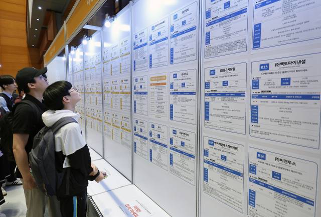 26일 서울 강남구 코엑스에서 열린 ‘2025 제1차 KB굿잡 우수 기업 취업박람회’에서 구직자들이 채용 공고 게시판을 둘러보고 있다. 연합뉴스