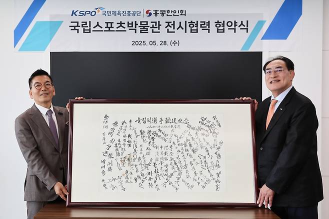 하형주 국민체육진흥공단 이사장(오른쪽)이 탁연균 홍콩한인회장과 함께 '1948 런던올림픽 참가 선수단 서명문' 액자를 들어 보이고 있다.
[국민체육진흥공단 제공. 재판매 및 DB 금지]