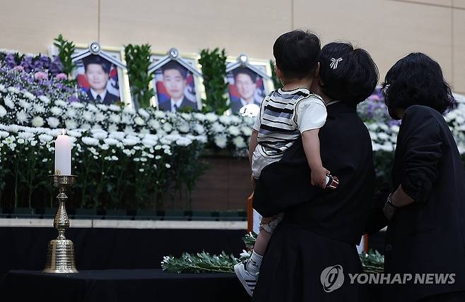 순직 해군 배웅하는 어린 아들 (포항=연합뉴스) 윤관식 기자 = 30일 경북 포항시 남구 해군 항공사령부 체육관에 마련된 '해군 P-3CK 917호기 순직자 합동분향소'에서 순직 해군의 유족과 어린 아들이 헌화하고 있다. 2025.5.30 psik@yna.co.kr