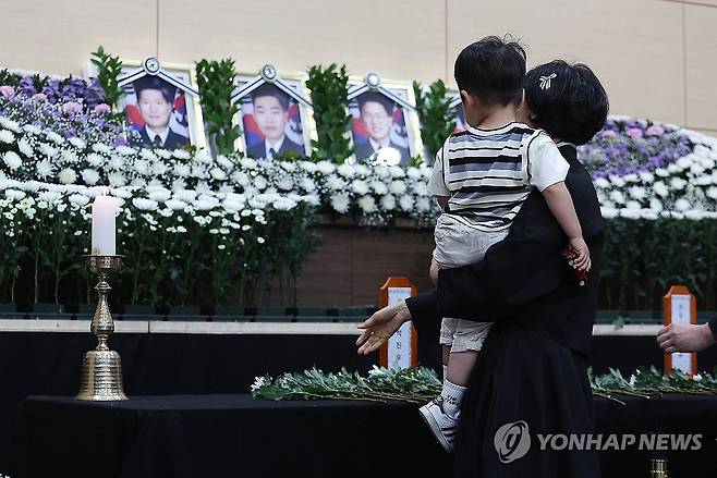순직 해군 배웅하는 어린 아들 (포항=연합뉴스) 윤관식 기자 = 30일 경북 포항시 남구 해군 항공사령부 체육관에 마련된 '해군 P-3CK 917호기 순직자 합동분향소'에서 순직 해군의 유족과 어린 아들이 헌화하고 있다. 2025.5.30 psik@yna.co.kr
