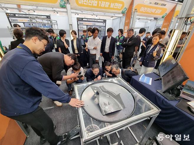 29일 경북 경산시 경일대 종합체육관에서 열린 ‘제2회 실리(SILI) 경진대회’에서 일본 자동차 업계 관계자들이 아진산업 자동화기술팀이 개발한 발판 이용 회전형 작업 테이블을 자세히 살펴보는 모습. 경산=김도형 기자 dodo@donga.com