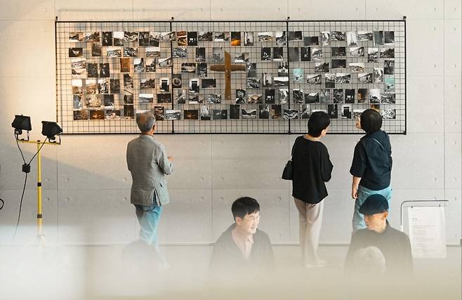 관람객들이 지난 19일 대전시 유성구 함께하는교회(김요한 목사) 지하 2층 갤러리에서 진행되는 ‘재(災), 건(建)’ 사진전을 감상하고 있다. 함께하는교회 제공