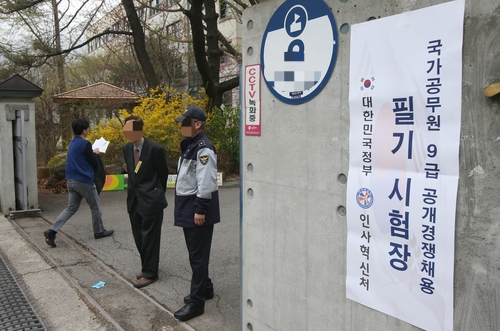 국가공무원 9급 필기시험장 앞으로 시민들이 지나가고 있다. 사진과 기사는 관련 없음. [사진 = 연합뉴스]