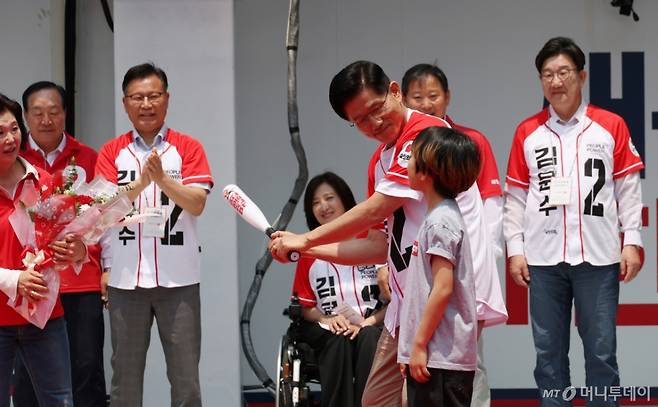 [속초=뉴시스]  김문수 국민의힘 대선 후보가 31일 강원 속초 관광수산시장에서 유세를 하기 전 선물받은 '역전홈런'이라고 쓰여진 야구 배트를 휘두르는 포즈를 취하고 있다. 2025.05.31.