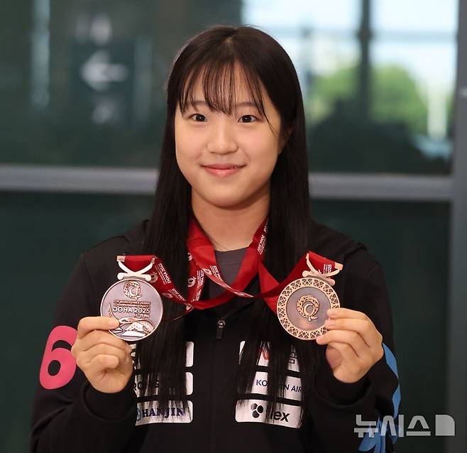 [인천공항=뉴시스] 추상철 기자 = 2025 국제탁구연맹(ITTF) 세계선수권대회에서 동메달 2개를 획득한 신유빈이 26일 오후 인천국제공항 제1터미널을 통해 귀국한 후 메달을 들어 보이고 있다. 025.05.26. scchoo@newsis.com