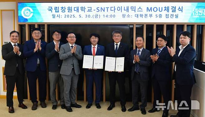 [창원=뉴시스]국립창원대학교 박민원(왼쪽) 총장과 SNT다이내믹스 박재석 대표이사가 30일 오후 국립창원대 대학본부에서 방산 전문인력 양성 업무협약을 체결한 후 관계자들과 기념촬영하고 있다.(사진=국립창원대 제공) 2025.05.31. photo@newsis.com